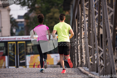 Image of multiethnic couple jogging in the city