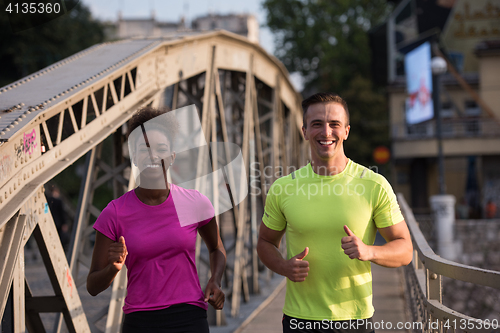 Image of multiethnic couple jogging in the city