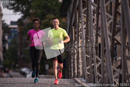 Image of multiethnic couple jogging in the city