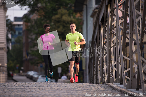 Image of multiethnic couple jogging in the city