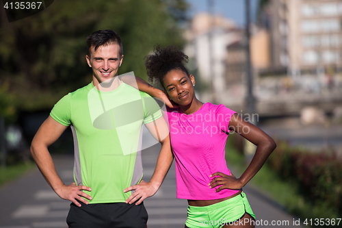 Image of portrait of young multietnic jogging couple ready to run