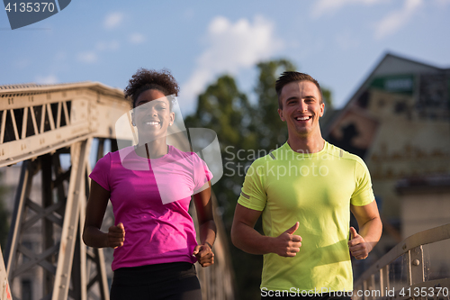 Image of multiethnic couple jogging in the city