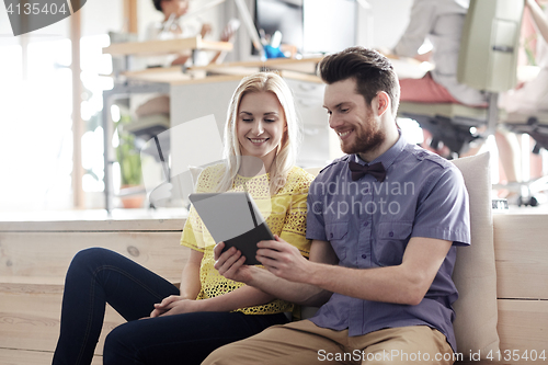 Image of happy creative team with tablet pc in office