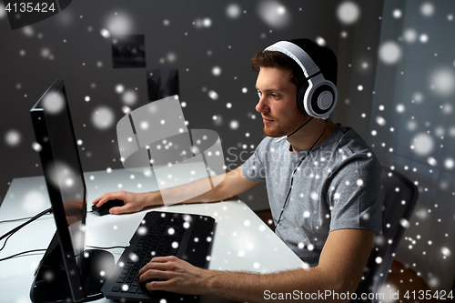 Image of man in headset playing computer video game at home