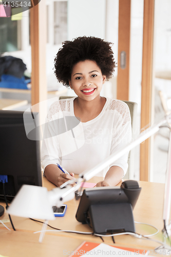 Image of businesswoman with computer and phone at office