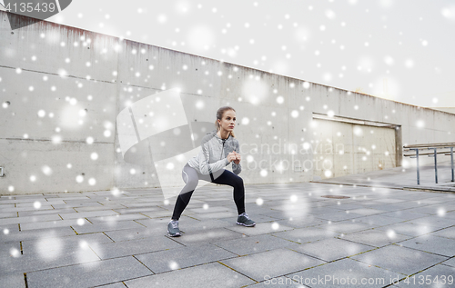 Image of woman doing squats and exercising outdoors
