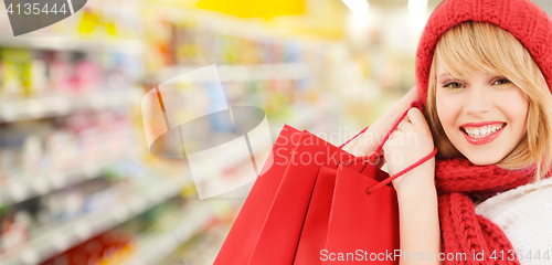 Image of woman in hat and scarf shopping at supermarket