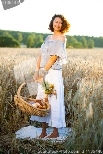 Image of beautiful woman in trendy summer dress in field