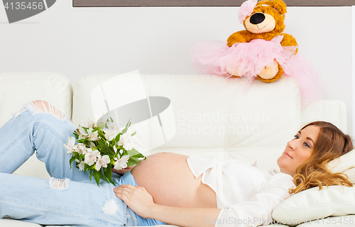 Image of Pregnant woman with a bouquet of flowers