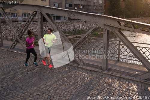 Image of young multiethnic couple jogging in the city