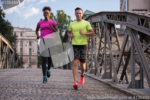 Image of multiethnic couple jogging in the city