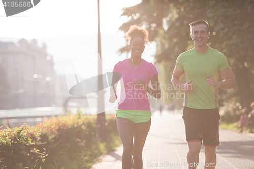 Image of young multiethnic couple jogging in the city
