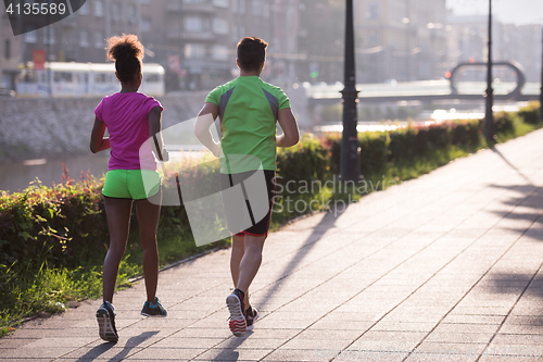 Image of young multiethnic couple jogging in the city