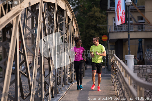 Image of multiethnic couple jogging in the city