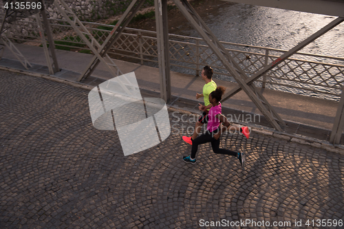 Image of young multiethnic couple jogging in the city