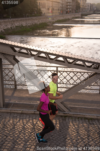 Image of young multiethnic couple jogging in the city