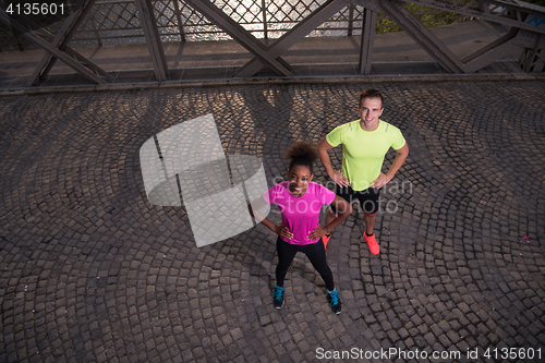 Image of portrait of a young multiethnic couple jogging in the city