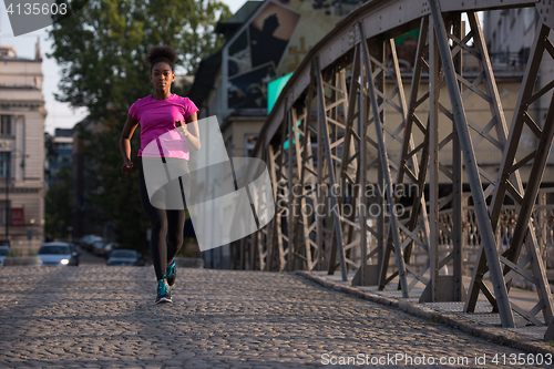 Image of african american woman running across the bridge