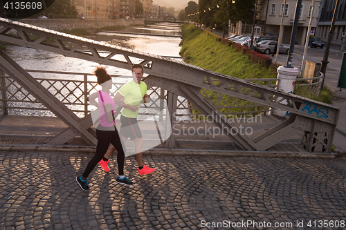 Image of young multiethnic couple jogging in the city