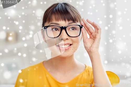 Image of happy asian young woman in glasses at home