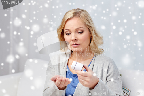 Image of middle aged woman with medicine at home