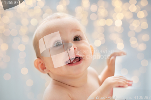 Image of happy little baby boy or girl looking up