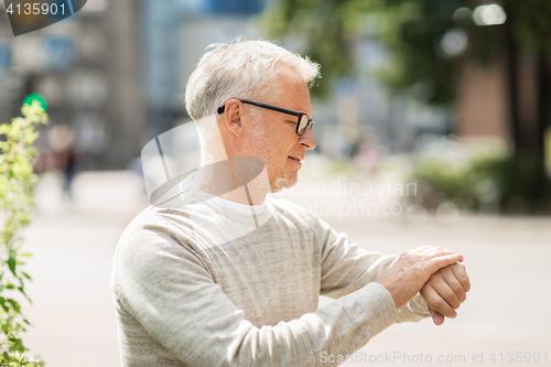 Image of senior man checking time on his wristwatch