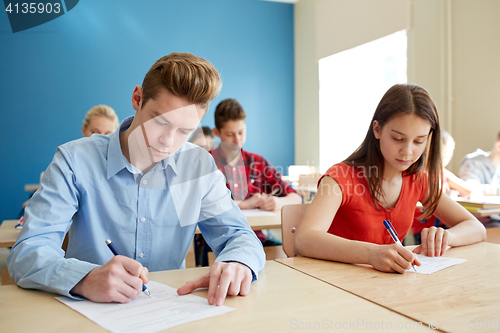 Image of group of students with books writing school test