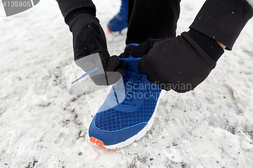 Image of close up of man tying shoe lace in winter outdoors