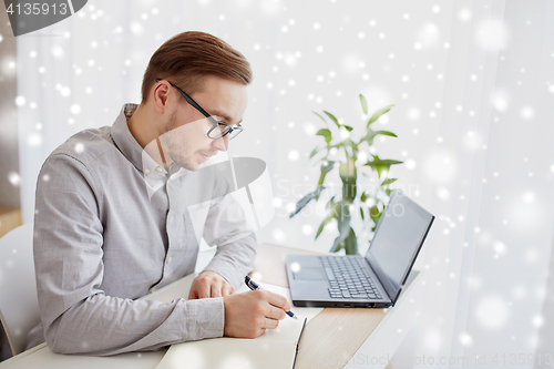 Image of creative man or businessman writing to notebook