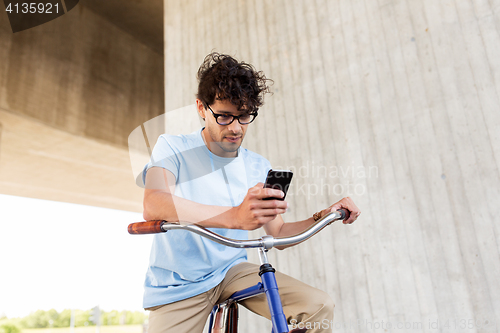 Image of man with smartphone and fixed gear bike on street