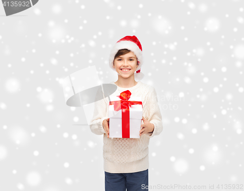 Image of smiling happy boy in santa hat with gift box