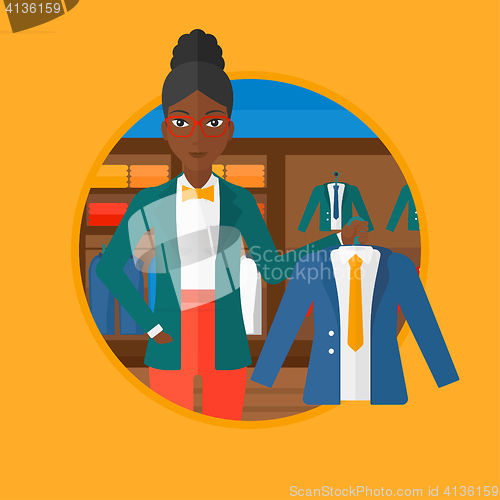 Image of Woman holding jacket in clothing store.