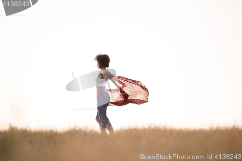 Image of black girl dances outdoors in a meadow