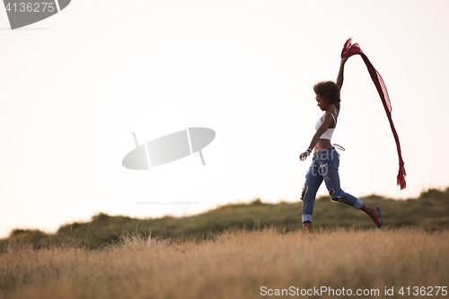 Image of black girl dances outdoors in a meadow