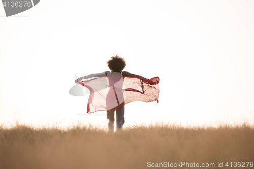 Image of black girl dances outdoors in a meadow