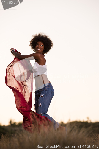 Image of black girl dances outdoors in a meadow