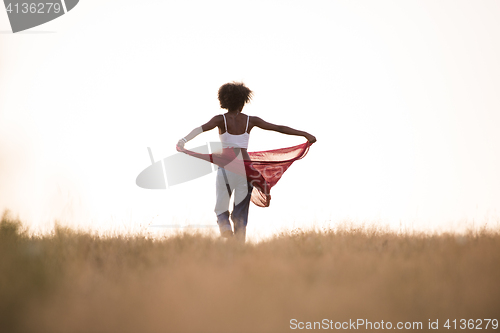 Image of black girl dances outdoors in a meadow