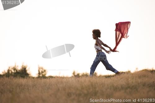 Image of black girl dances outdoors in a meadow