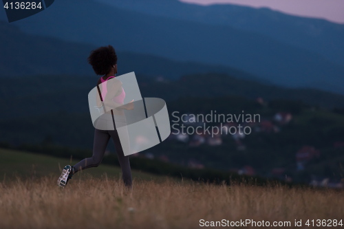 Image of Young African american woman jogging in nature