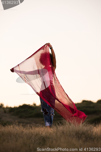 Image of black girl dances outdoors in a meadow