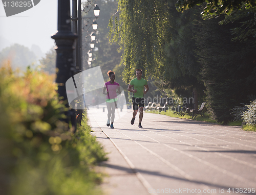 Image of young multiethnic couple jogging in the city