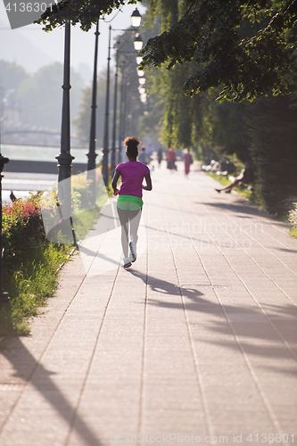 Image of african american woman jogging in the city