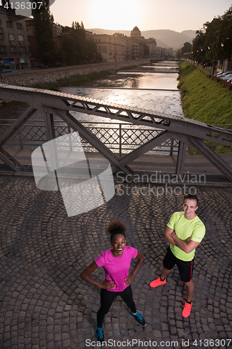 Image of portrait of a young multiethnic couple jogging in the city