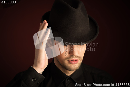 Image of a young man  with  make  up and painted tears. 