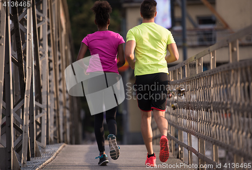 Image of multiethnic couple jogging in the city