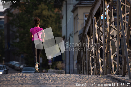 Image of african american woman running across the bridge