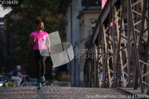 Image of african american woman running across the bridge