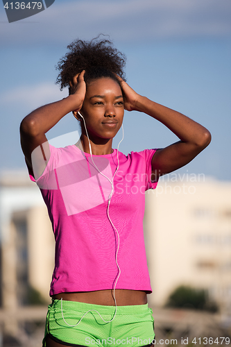 Image of young african american woman running outdoors