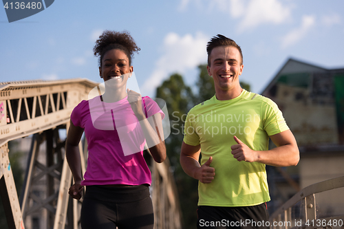 Image of multiethnic couple jogging in the city